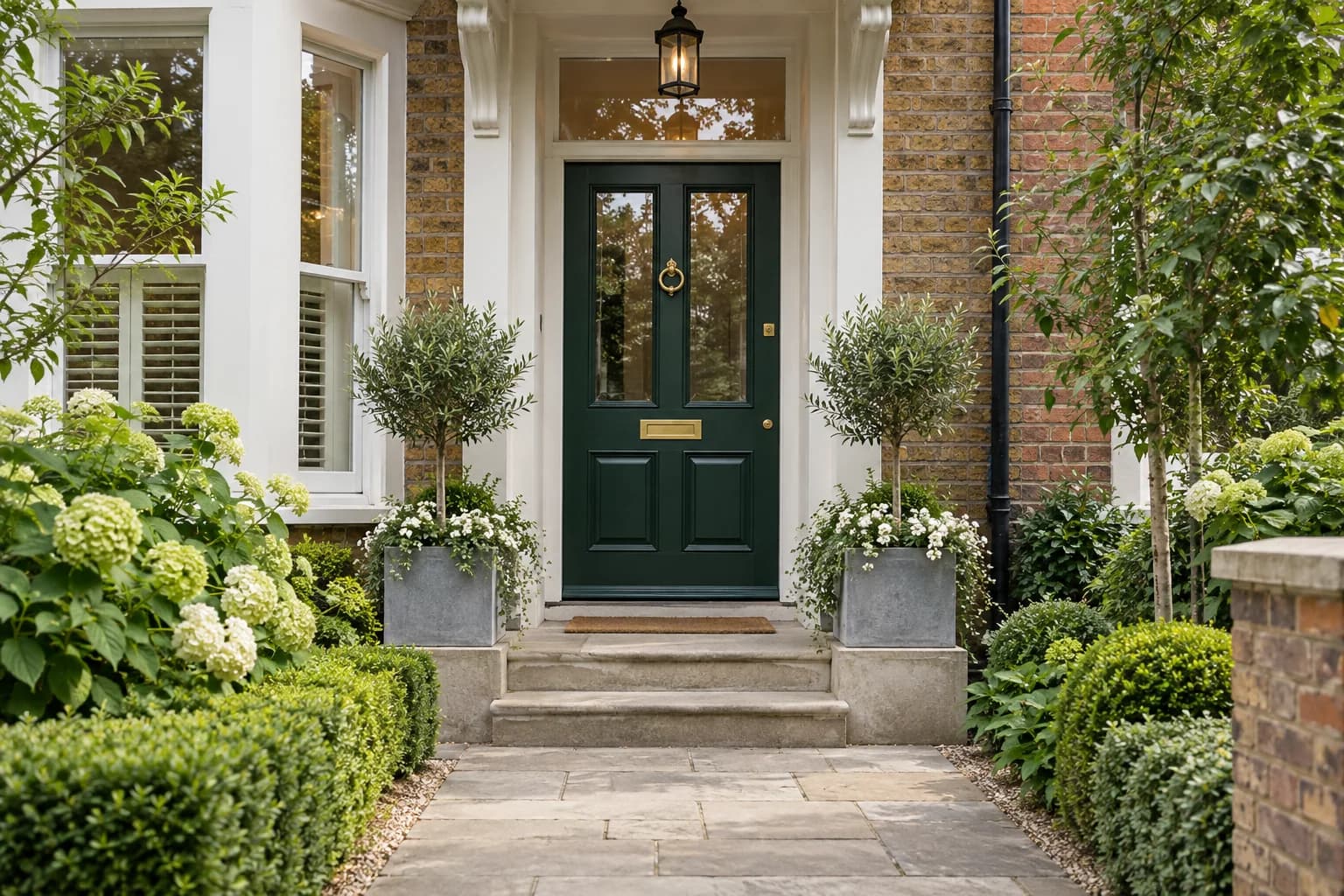 Well-kept British home entrance with a deep green front door
